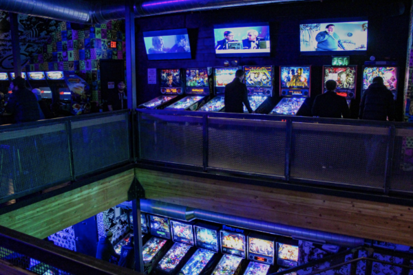 A large arcade room showcasing a variety of pinball machines, each brightly lit and ready for players to enjoy A large arcade room showcasing a variety of pinball machines, each brightly lit and ready for players to enjoy