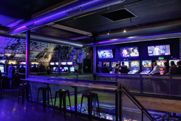 A bar featuring a large screen and several stools arranged for patrons to sit and enjoy drinks or watch events A bar featuring a large screen and several stools arranged for patrons to sit and enjoy drinks or watch events