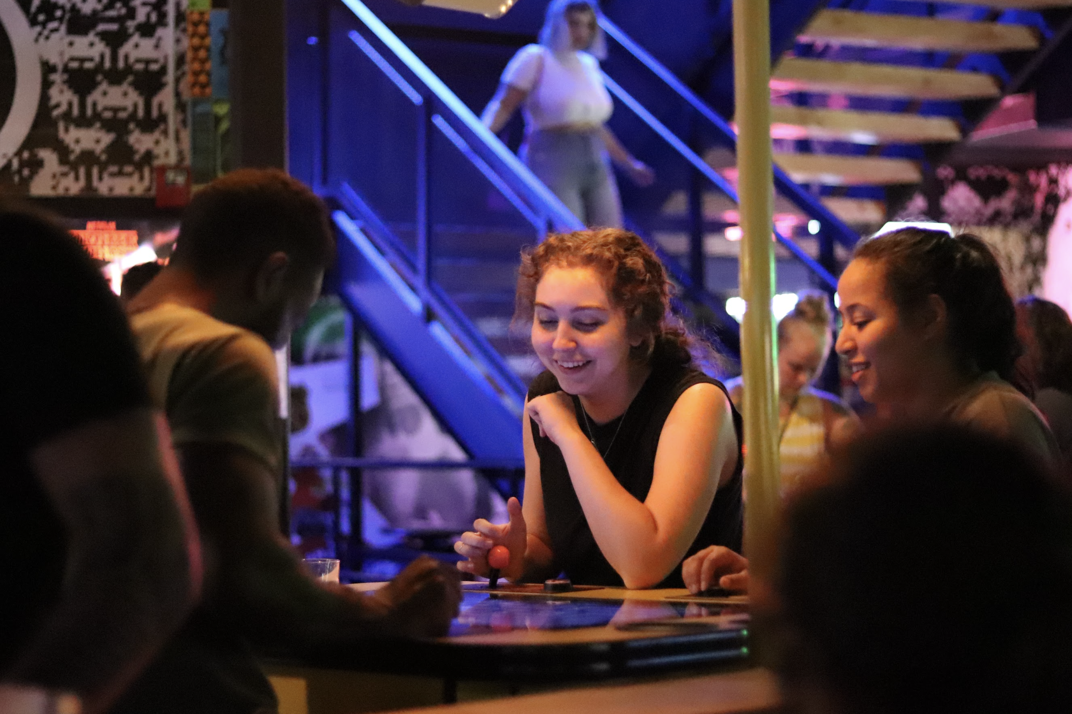 A group of people seated at a table, including a man and a woman engaged in conversation.