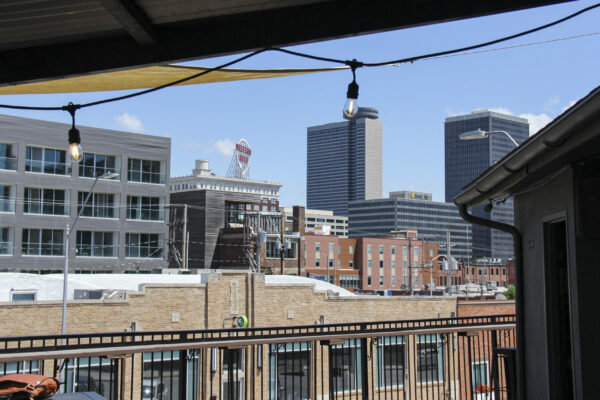 A panoramic view of the city skyline from a balcony, showcasing buildings and streets under a clear blue sky A panoramic view of the city skyline from a balcony, showcasing buildings and streets under a clear blue sky