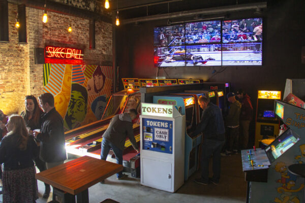 A lively group of friends enjoying games together in a vibrant bar setting, laughing and engaging with each other. A lively group of friends enjoying games together in a vibrant bar setting, laughing and engaging with each other.