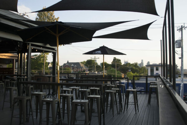 Scenic rooftop deck at the Riverhouse with comfortable seating and greenery, overlooking the river and city skyline Scenic rooftop deck at the Riverhouse with comfortable seating and greenery, overlooking the river and city skyline