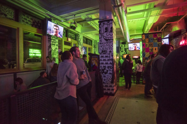 A group of people stands in a dimly lit room illuminated by vibrant neon lights. A group of people stands in a dimly lit room illuminated by vibrant neon lights.