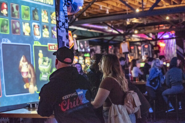 People enjoying themselves while playing slot machines in a lively bar atmosphere People enjoying themselves while playing slot machines in a lively bar atmosphere